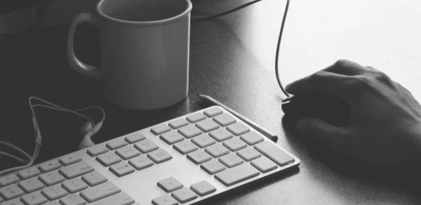 black and white hand on mouth near keyboard